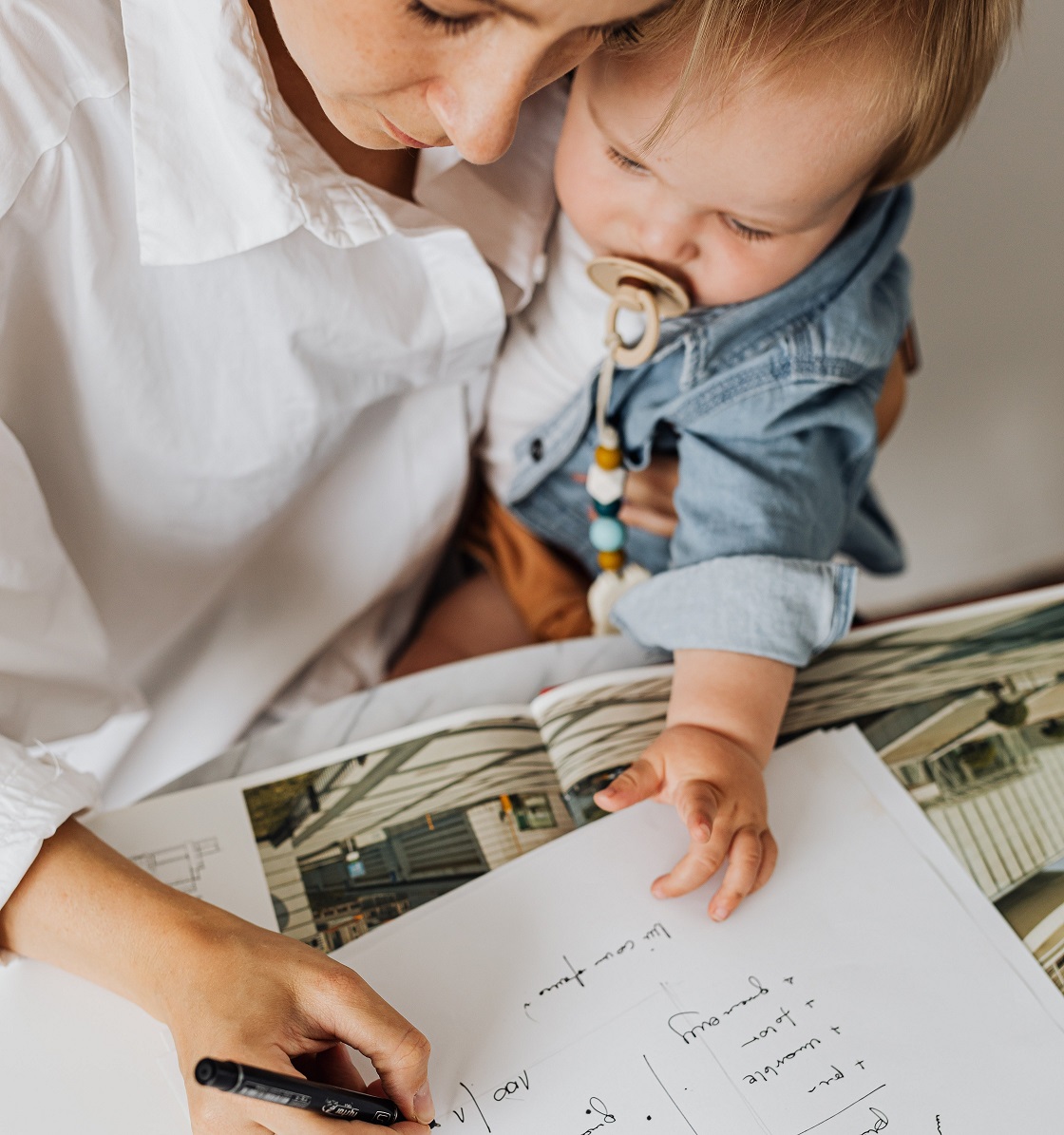 Mother with baby writing something on a paper